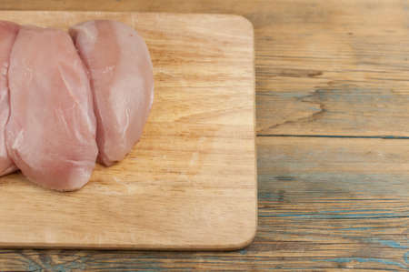 Chicken fillet on a wooden cutting board. Raw, fresh chicken fillet. Chicken fillet cut in the form of a butterfly.Top View.の写真素材
