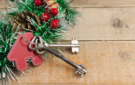 Beautiful Christmas background: decorative house and key to the lock on old wood barn plank. Concept of finance and housing loans. Real estate conceptの写真素材