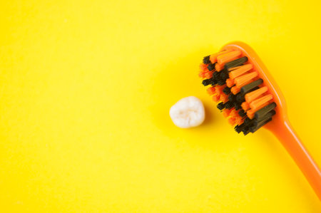 Tooth brush and deciduous milk child teeth on yellow backgroundの写真素材