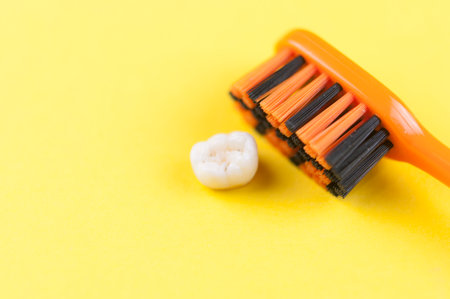 Tooth brush and deciduous milk child teeth on yellow backgroundの写真素材