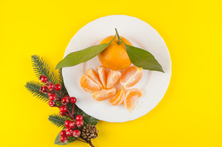 Fresh oranges bowl with green leaf on yellow backgroundの写真素材
