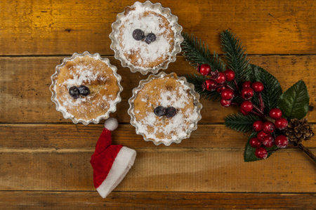 holiday cupcakes decorated with powdered sugar and Christmas decoration on wooden table. Top viewの写真素材