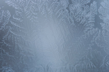 Photographing macro ice on the glass in winter. Beautiful festive frosty pattern with white...