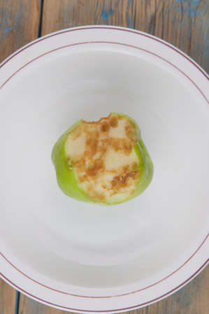 old apple bitten photographed on wood background.の写真素材