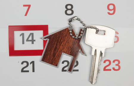 A house key on a calendar background, paying your mortgage on timeの写真素材