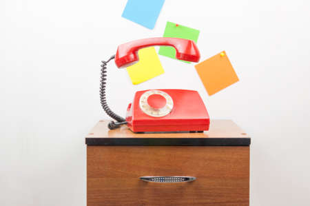 Urgent call waiting, classic red telephone receiver, old telephone on white background, flying in...