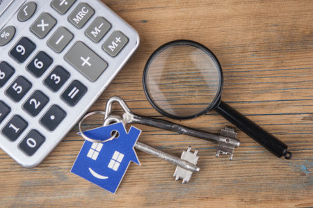 Property assessment. Miniature house with key, magnifier and calculator. Real estate conceptの写真素材