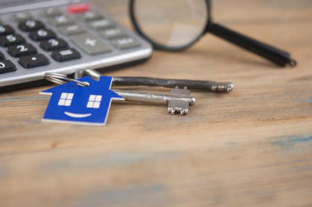 Property assessment. Miniature house with key, magnifier and calculator. Real estate conceptの写真素材