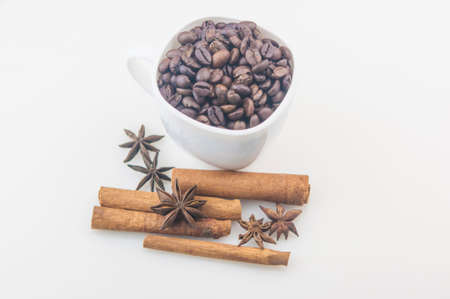 Coffee cup with beans, anise and cinnamon on white background.の写真素材