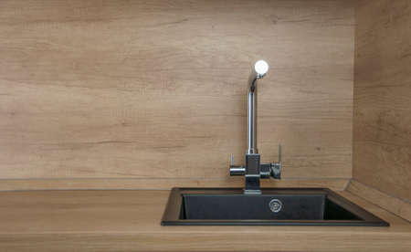 Black kitchen sink and Tap water in the kitchen. The interior of the kitchen room of the apartment. Built-In Appliances. Kitchen Appliance. Domestic Appliancesの写真素材