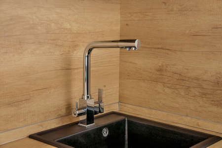 Black kitchen sink and Tap water in the kitchen. The interior of the kitchen room of the apartment. Built-In Appliances. Kitchen Appliance. Domestic Appliancesの写真素材