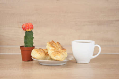 Two bun with poppy seeds with coffee cup on wood table. Breakfast. Good Morning. Coffee timeの写真素材