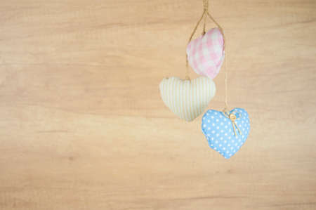 Fabric colorful hearts hanging on brown wooden wall. Happy valentines dayの写真素材
