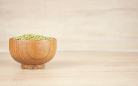 Mung bean, green moong dal in wooden bowl. Copy space. Wooden background.の写真素材