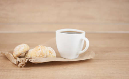 orange snowball cookies with coffee cup on wood tableの写真素材