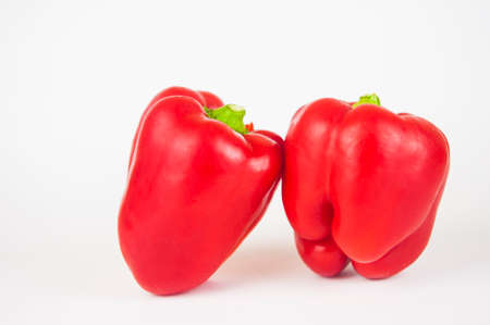 two red sweet bell peppers on white backgroundの写真素材