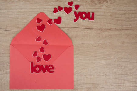 envelope with red paper hearts on wood backgroundの写真素材