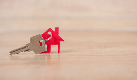House symbol with metal key on wood table. Real estate, insurance concept, mortgage, buy sell house, realtor conceptの写真素材