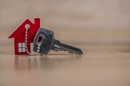 House symbol with metal key on wood table. Real estate, insurance concept, mortgage, buy sell house, realtor conceptの写真素材