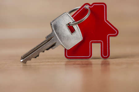 House symbol with metal key on wood table. Real estate, insurance concept, mortgage, buy sell house, realtor conceptの写真素材