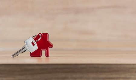 House symbol with metal key on wood table. Real estate, insurance concept, mortgage, buy sell house, realtor conceptの写真素材