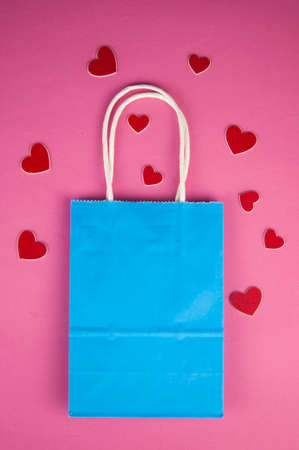 Online shopping concept. Top view gift shopping bag, and red paper hearts on pink background, copy space, flat lay. Background for Valentine's Day, Birthday, Mother's Dayの写真素材