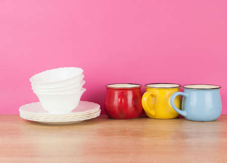 Set of various colorful dishware and cutlery on wooden tableの写真素材