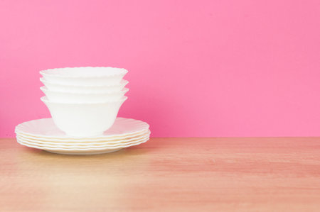 Set of various white dishware and cutlery on wooden tableの写真素材