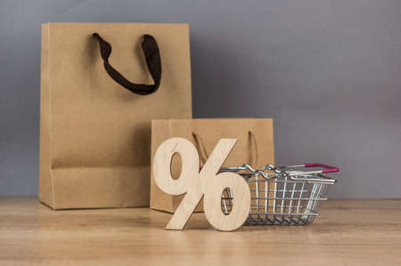 Set blank brown paper carrier bags with handles for shopping on wood table