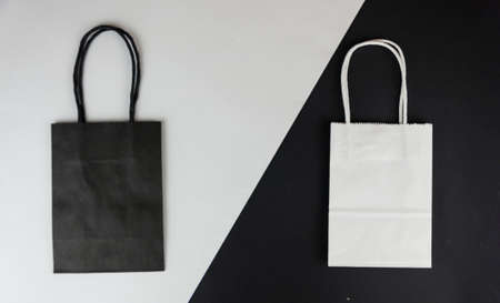 The composition is shot from above on two sheets of paper. Two empty paper bags with handles for...