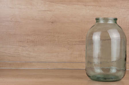 Blank glass transparent jar on wooden table background. Copy, empty space for textの写真素材