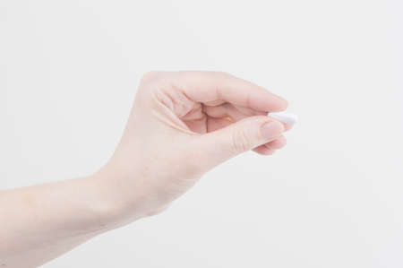 Doctor's appointment, Taking pills, hand with the one pill on a white background. Healthcare and...