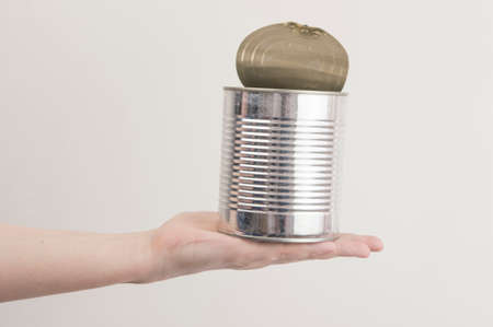 Female hand holding open empty tin can. Recyclable waste. Recycling, reuse, garbage disposal, resources, environment and ecology conceptの写真素材