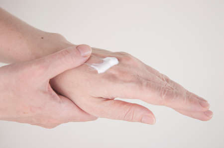 Close up of arm of young woman applying cream on her handの写真素材