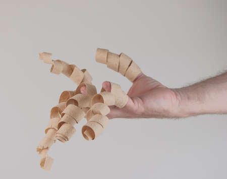 wood shavings hanging from the fingers over white background