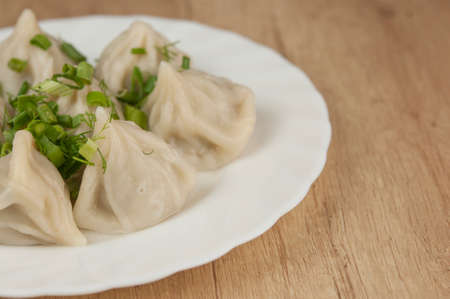 khinkali on a white plate sprinkled with green onionsの写真素材