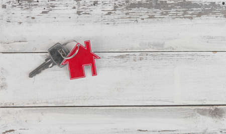 Key and house shaped keychain arrangement on old white wood background. Top view, flat lay. Real estate, insurance concept, mortgage, buy sell house, realtor conceptの写真素材
