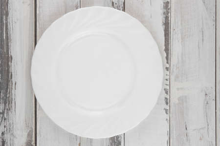 An empty white plate on light wooden planks, Natural wood, blank space for text, copy spaceの写真素材
