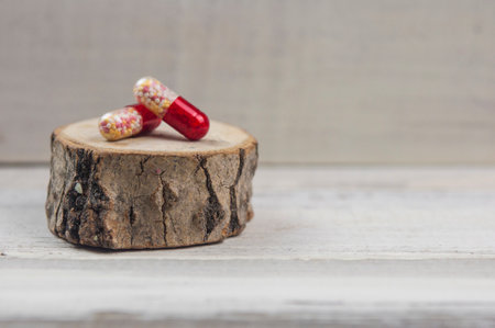 colorful pills for diseases in packages and scattered on the tableの写真素材