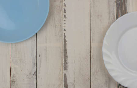 Top view of an empty ceramic plate on a rustic white wooden table