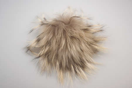 Close up rabbit fur pompom on white background. Brown fur.