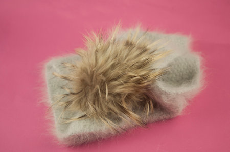 Woman winter knitted scarf front on pink background.
