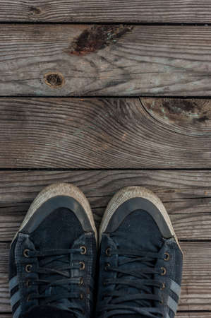 Front parts of pair of blue sneakers on dry wooden planks background. top view