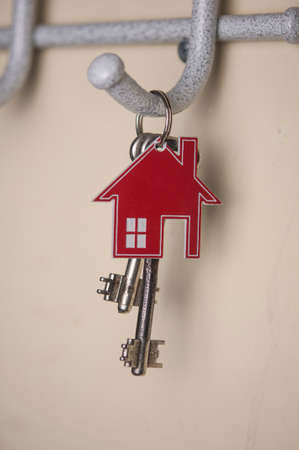 A bunch of vintage metal keys on ring hanging on hooks metal hangersの写真素材