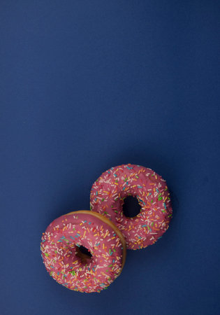Raspberry fresh homemade donuts on a dark blue background. Top viewの写真素材