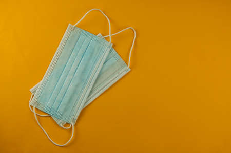 bunch of new blue masks laying on yellow background. Top viewの写真素材