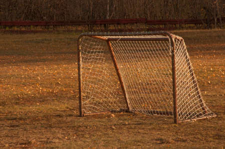 Old iron rusty football goal for mini football on trampled lawn in forest zone of city park.の写真素材