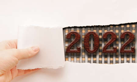 The numbers 2022 are written on a white torn sheet of paper. New Year. Copy space