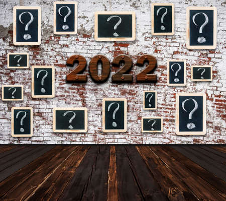 2022 Happy New Year seasonal background in large empty room with question marks - white chalk...