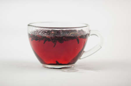 Karkade. Tea drink in a glass. Red liquid in a glass. Dried petals. Hibiscus. Sudanese roseの写真素材